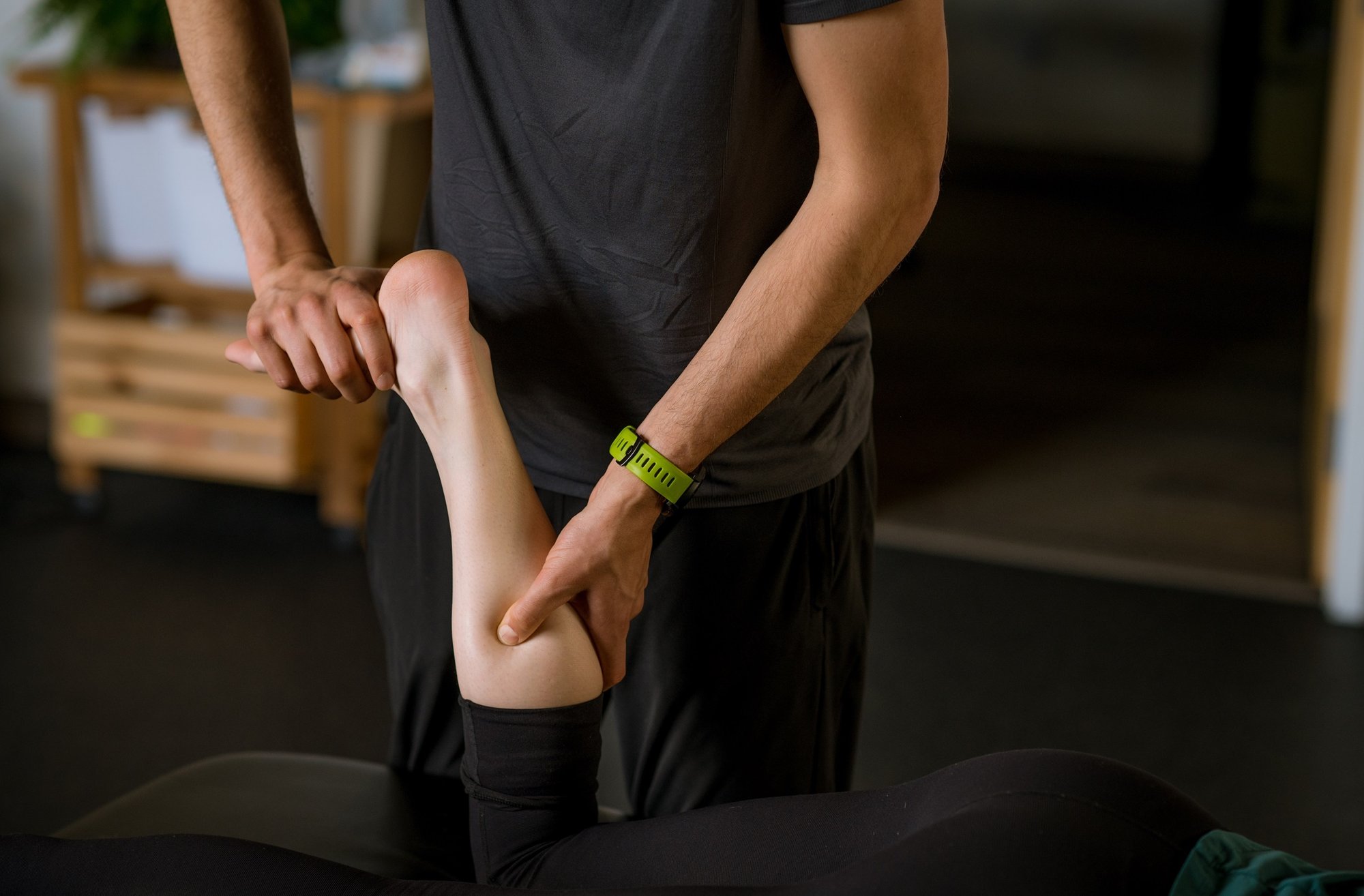 A Portland Maine Physical Therapist performing manual therapy on a runner's calf.