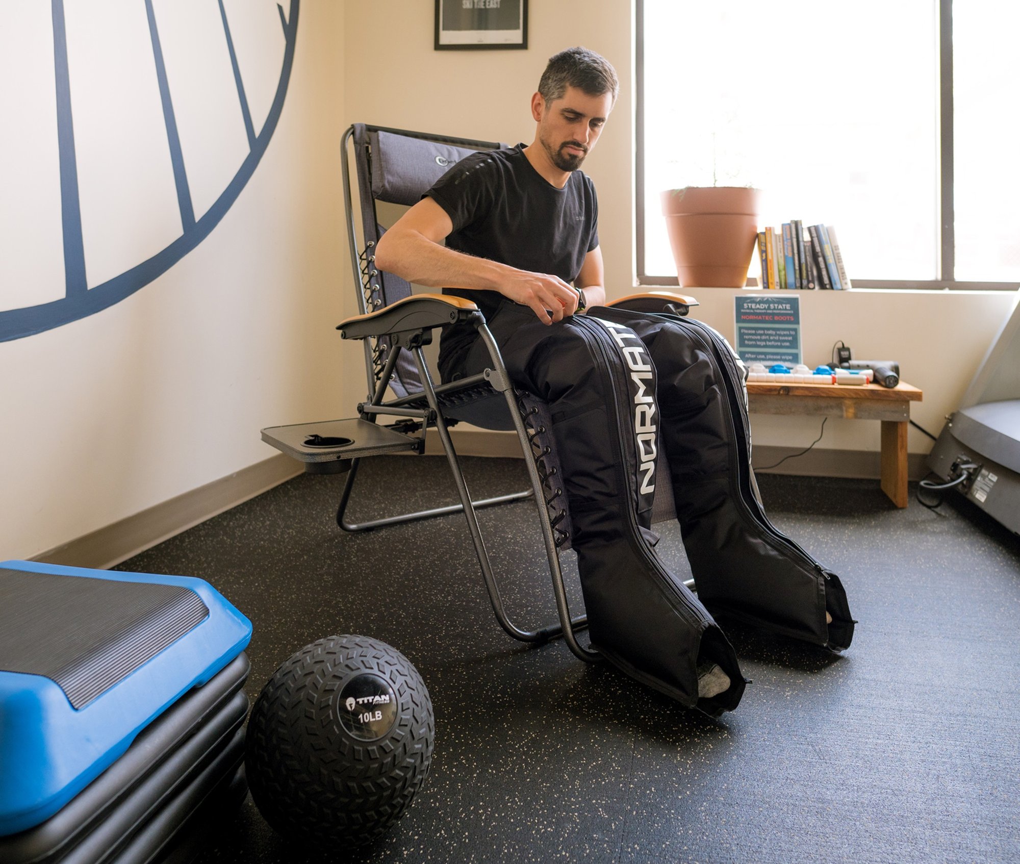 A runner in Portland Maine getting into a pair of Normatec Compression Therapy boots.