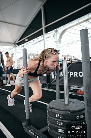 Dr. Brenna Johnson pushing the sled at Hyrox New York.