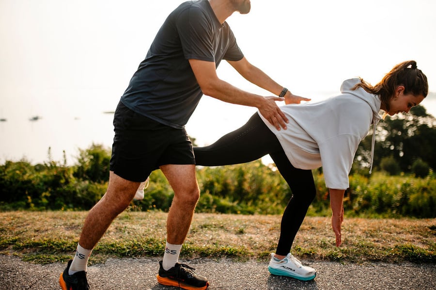 A Steady State running physical therapist helping a runner with a running drill.