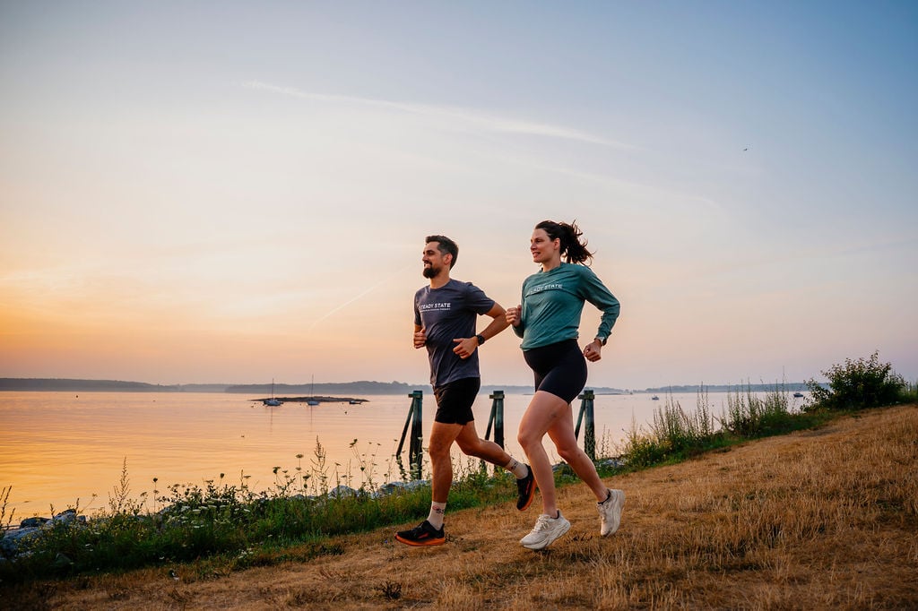 Kelton and Ashten running along the Eastern Prom in Portland, Maine at sunrise.