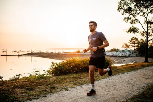 A runner on a coastal path at sunrise in Portland, Maine
