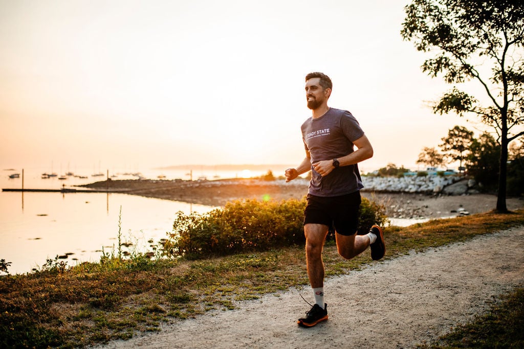A runner on a coastal path at sunrise in Portland, Maine