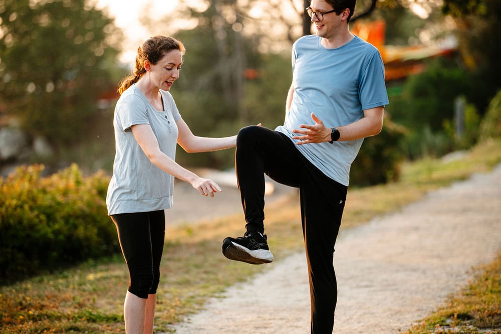 A Steady State physical therapist assessing a runner's knee drive on a trail in Portland, Maine