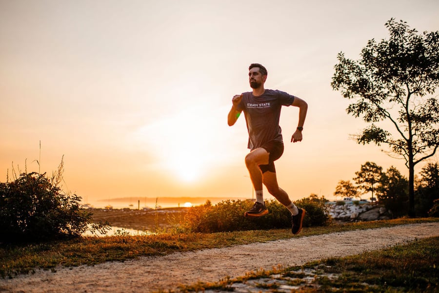 A runner on a coastal trail at sunset in Portland, Maine.