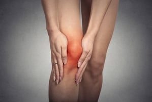 A runner holding their painful knee.