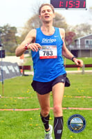A Maine runner crossing the finish line of a half marathon.