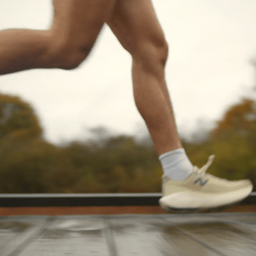 A close up of a runner's legs while running over a wooden bridge.