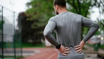 Runner having low back pain on the track.