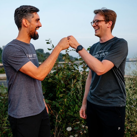 2 Steady State run coaches giving each other a fist bump. 2 Steady State run coaches giving each other a fist bump.