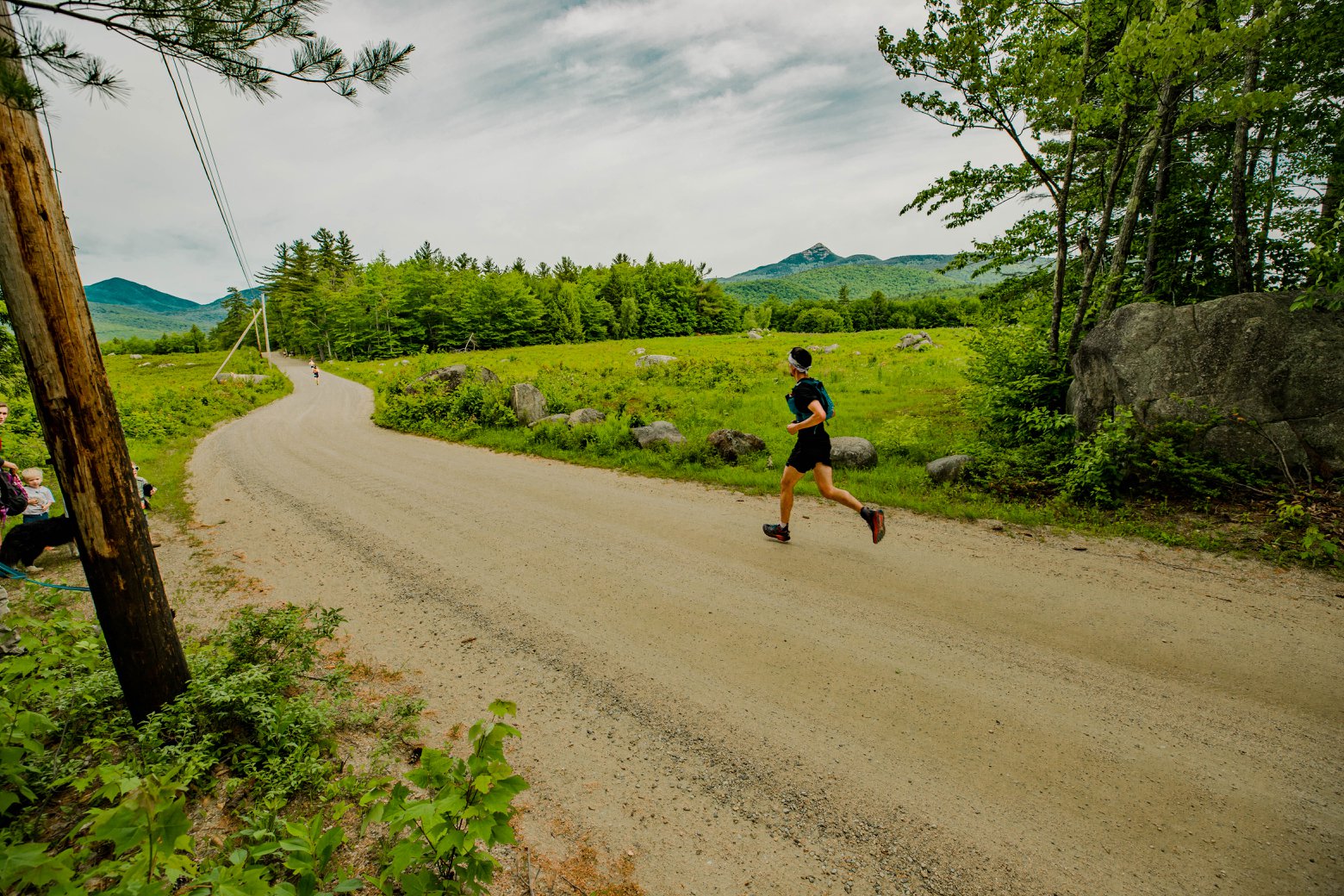 A runner running on a dirt road in the White Mountains of New Hampshire.