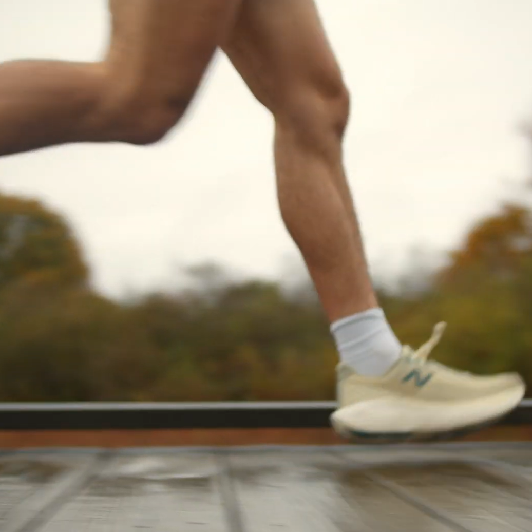 A close up of a runner's legs while running over a wooden bridge.